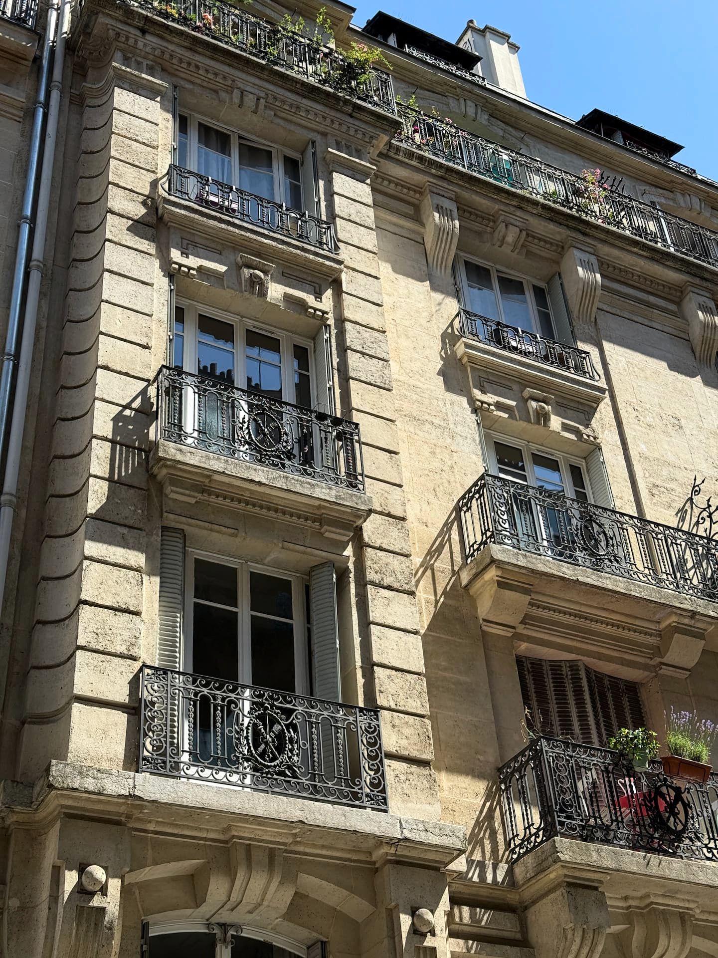 Photo extérieure des fenêtres en bois d'un appartement haussmannien à Paris remplacé par Ludovic COLAS, artisan menuisier et dirigeant CMS Menuiserie.