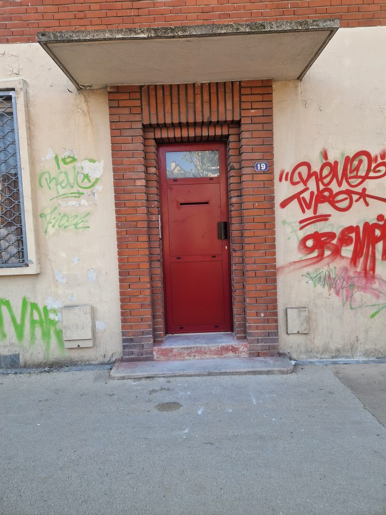 Après remplacement porte aluminium entrée commune copropriété couleur rouge avec gâche électrique posée par CMS Menuiserie.