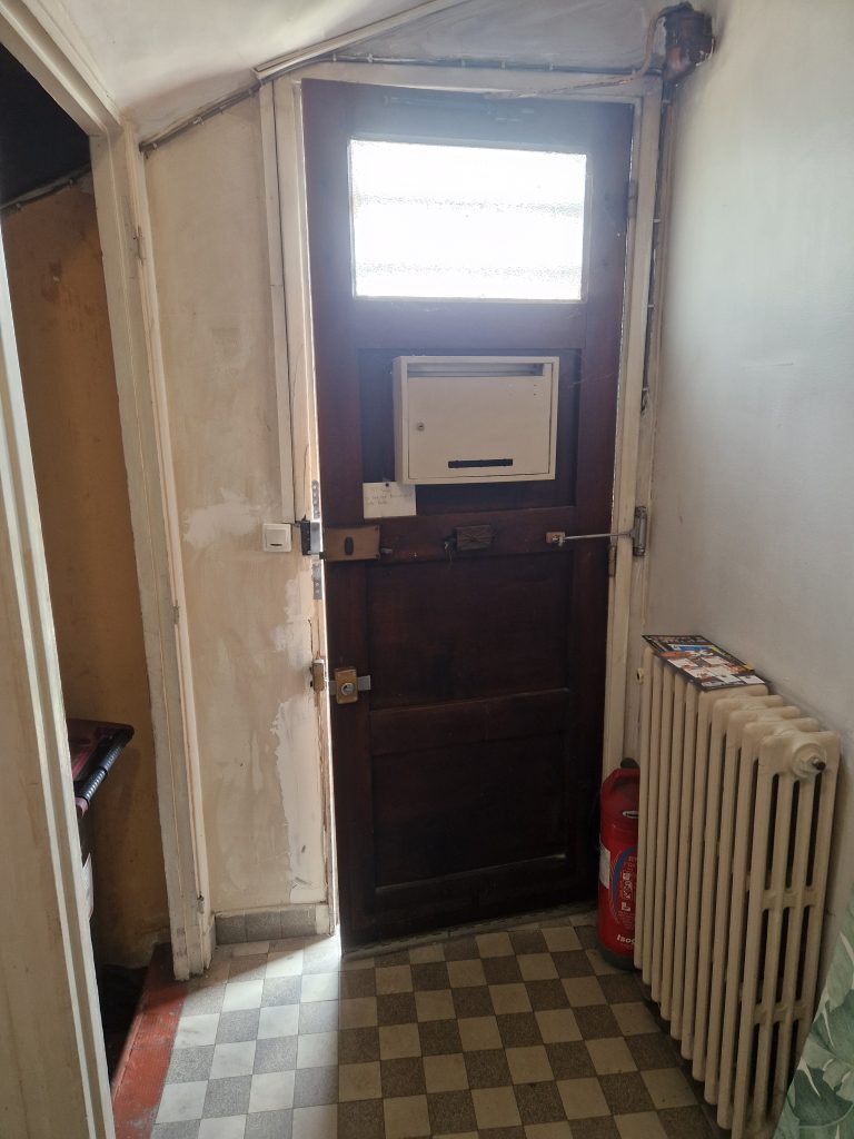 Avant remplacement porte entrée commune intérieur copropriété en région parisienne.
