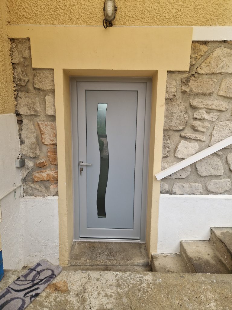Extérieur porte d'entrée couleur gris Fichet Forstyl posée sur un pavillon en Île-de-France par Ludovic COLAS, menuisier et dirigeant CMS Menuiserie.