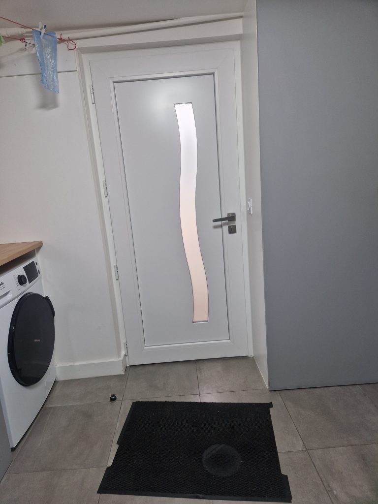 Intérieur porte aluminium couleur blanche sous-sol installée dans un pavillon de style meulière. Travaux réalisé par CMS Menuiserie basé à Noisy-le-Grand (93).