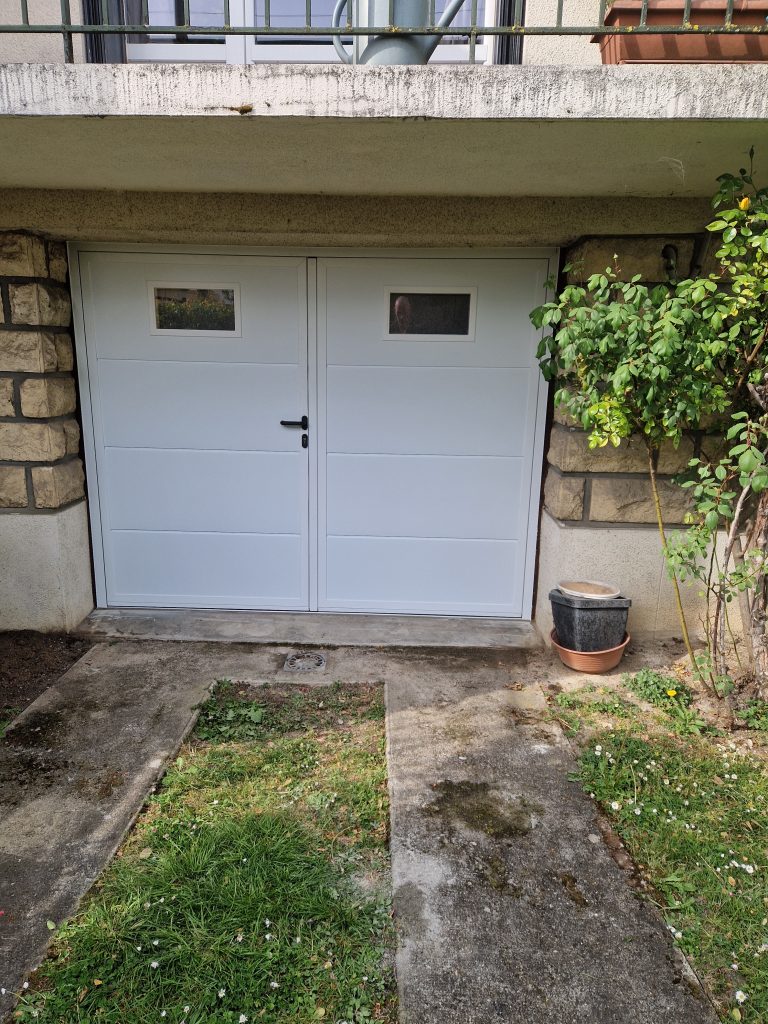 Extérieur porte de garage battante 2 vantaux installée en Île-de-France par Ludovic COLAS, artisan menuisier.