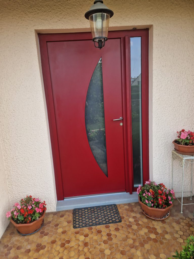 Extérieur porte tiercée aluminium Fenetrêa couleur rouge posée sur un pavillon à Bondy en Seine-Saint-Denis. Travaux réalisé apr Ludovic COLAS, menuisier et dirigeant CMS Menuiserie basé à Noisy-le-Grand (93).