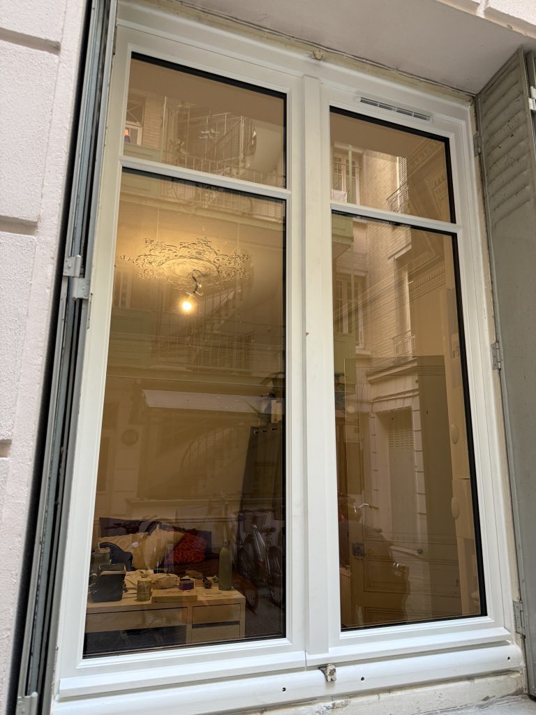 Vue extérieure de la nouvelle fenêtre d'un studio parisien installée par Ludovic COLAS, artisan menuisier et dirigeant CMS Menuiserie.