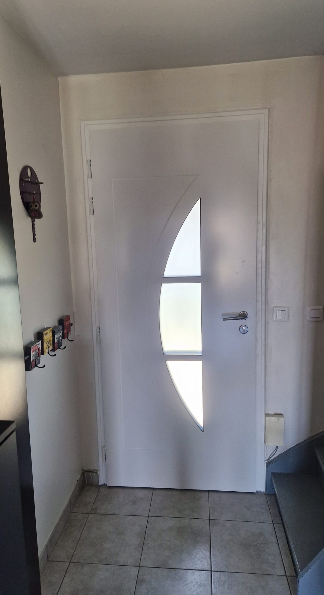 Intérieur porte aluminium laquée blanc Fenetrêa posée dans un pavillon en Île-de-France par Ludovic COLAS, menuisier et dirigeant CMS Menuirie à Noisy-le-Grand (93).
