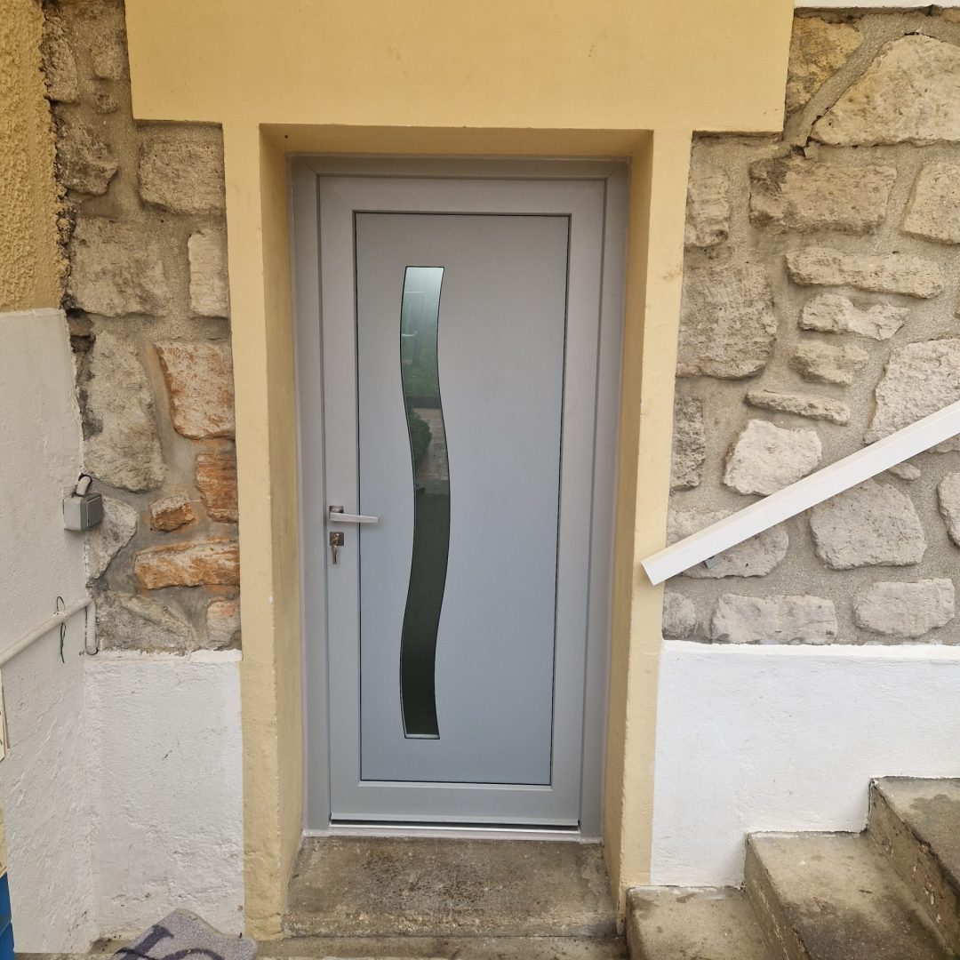 Extérieur porte d'entrée couleur gris Fichet Forstyl posée sur un pavillon en Île-de-France par Ludovic COLAS, menuisier et dirigeant CMS Menuiserie.